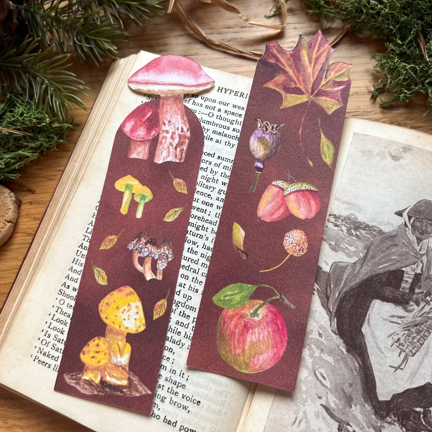 Fall Forage and Woodland Walk bookmarks sat on an open poetry book, resting in a wooden desk decorated with green moss and straw