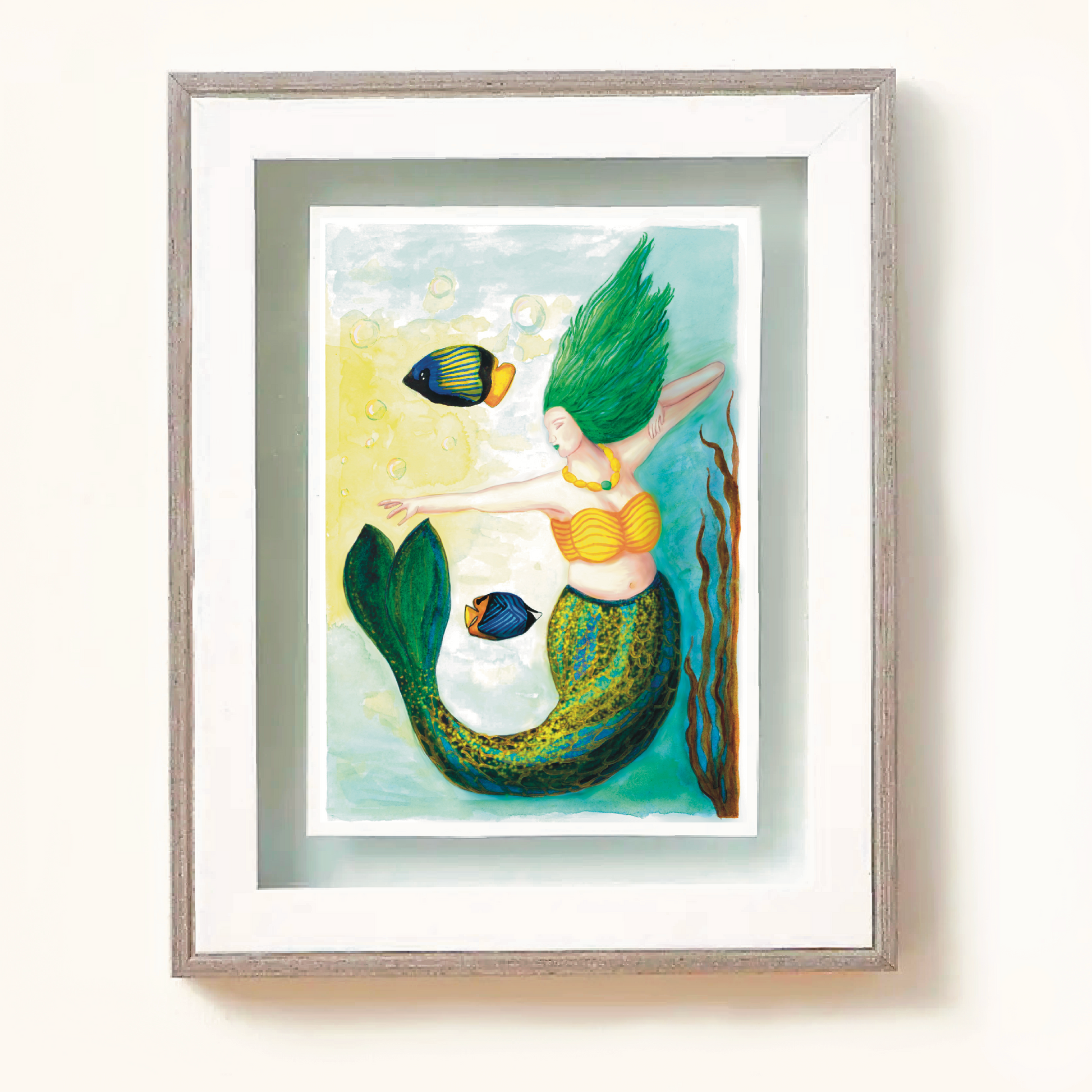 Framed art print of Stripe mermaid. Stripe has a blue green and gold striped tail, green flowing long hair and is pointing towards a glowing yellow light, and two fish swim nearby.