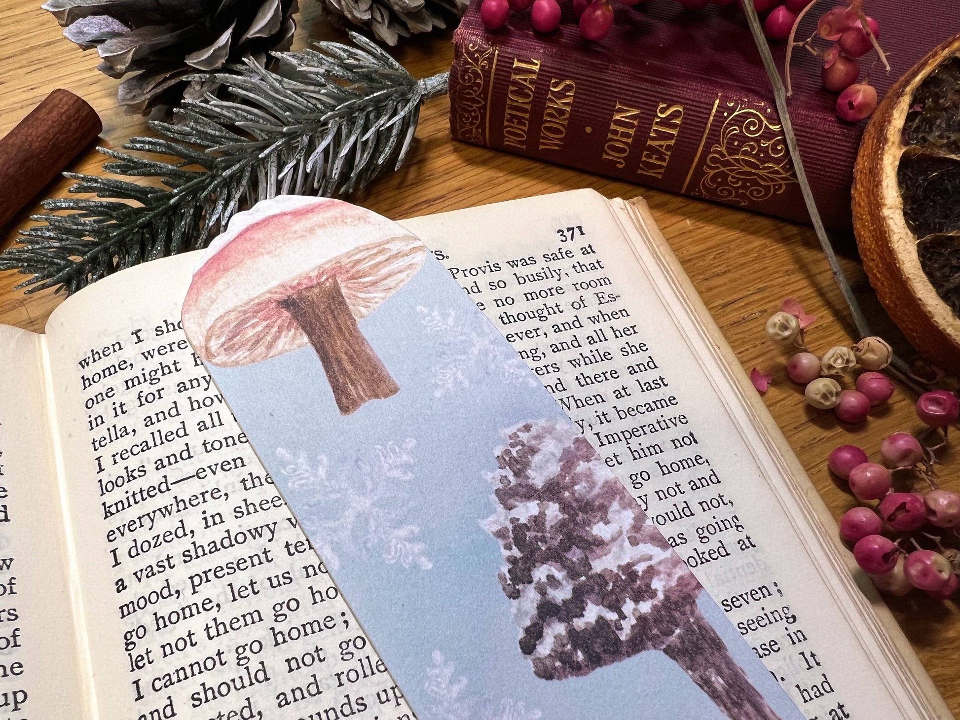 Winter wanderland snow topped mushroom illustrated bookmark, cut at the top to the shape of a snow topped milkcap mushroom