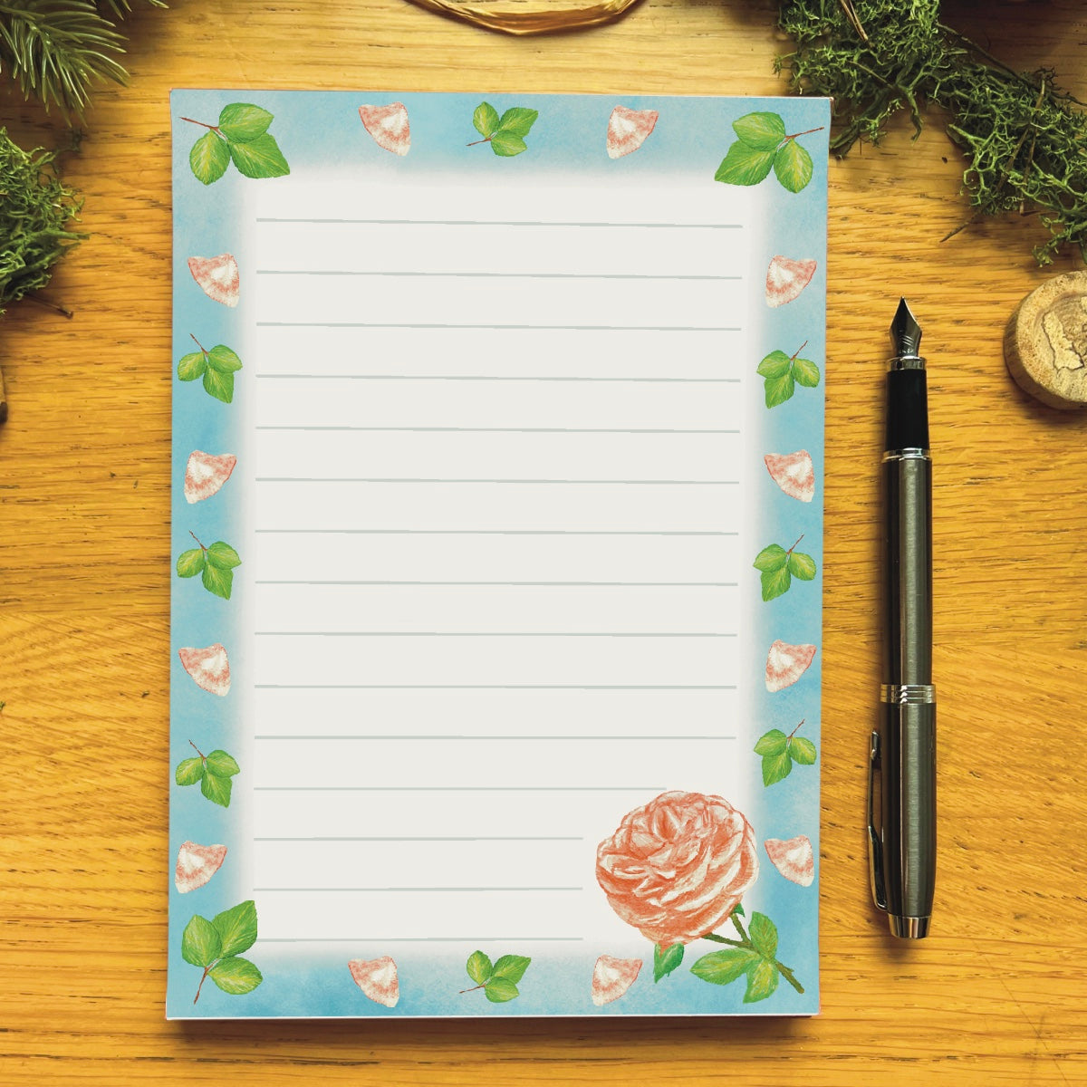 Peach rose illustrated notepad with sky blue border decorated with peach petals and leaves