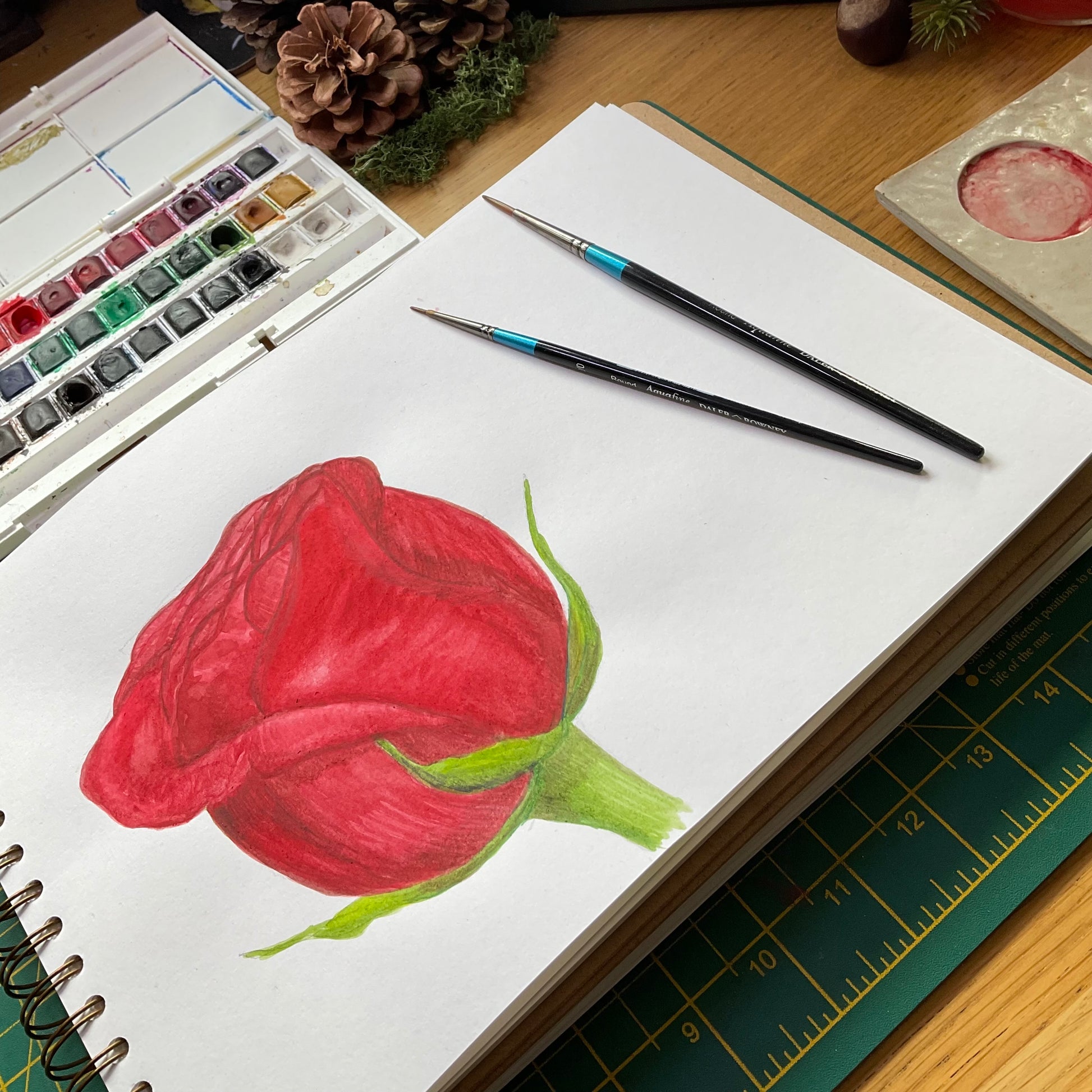 Sketchbook watercolour painting of a red rose bud by Kat Lovatt 