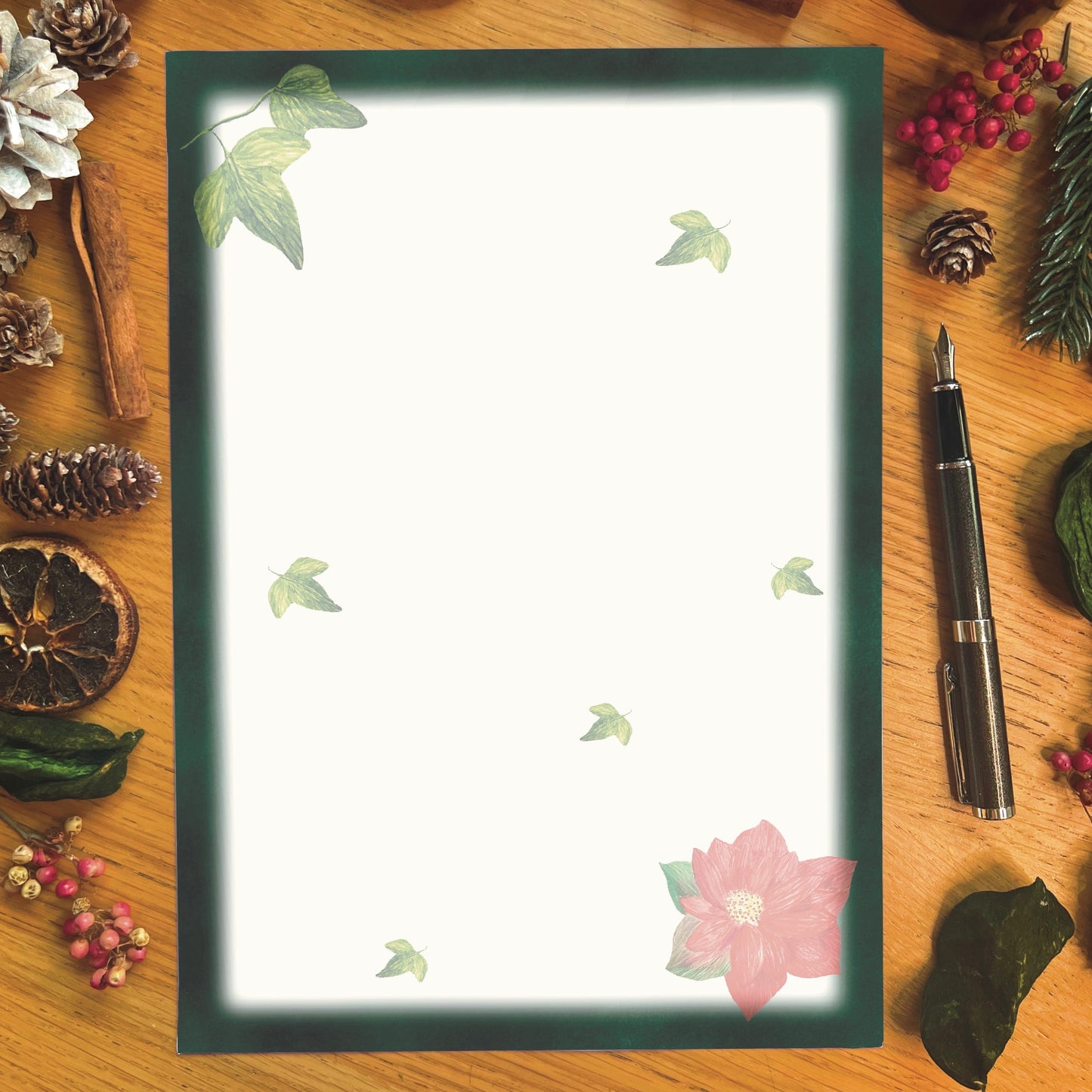 Winters bloom letter writing page.  Red poinsettia and ivy illustrated page with dark green border