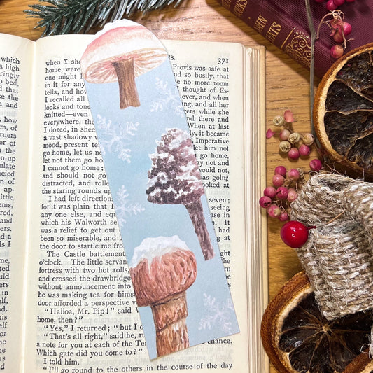 Winter wanderland snow topped mushroom illustrated bookmark, cut at the top to the shape of a snow topped milkcap mushroom